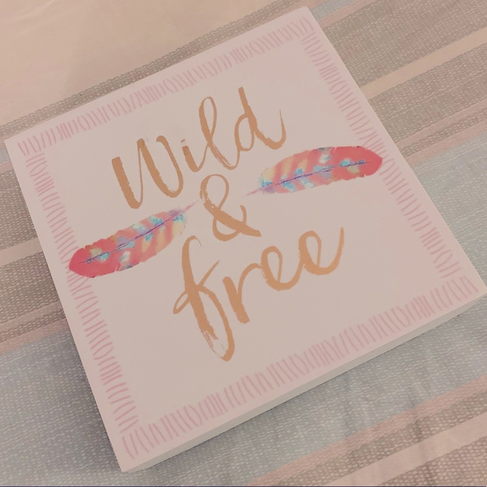 White wall art “Wild and Free” saying with boho design.Wild